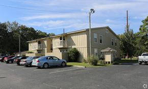Foley apartment for rent - A parking lot with cars and a building in the background.