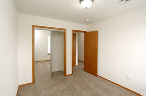 Edmond triplex for rent - a bedroom with a carpeted floor and a door to a closet