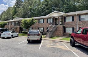 Canton apartment for rent - a parking lot with cars in front of a brick apartment building