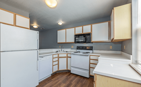 St. Robert townhouse for rent - a kitchen with white appliances and wooden cabinets