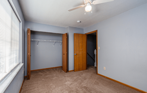 St. Robert townhouse for rent - a bedroom with a closet and a window and a ceiling fan