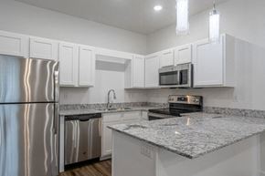 Bentonville apartment for rent - a kitchen with white cabinets and granite counter tops
