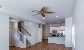 Alexander apartment for rent - a living room with a staircase to the right and a kitchen in the background
