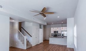 Alexander apartment for rent - a living room with a staircase to the right and a kitchen in the background