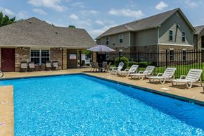 Conway apartment for rent - a swimming pool with chaise lounges and umbrellas in front of a house