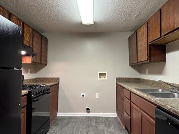 College Park apartment for rent - a kitchen with wooden cabinets and a stove and a sink