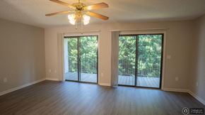 Hickory apartment for rent - an empty living room with a ceiling fan and sliding glass doors