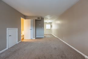 Augusta townhouse for rent - an empty living room with carpet and a door into a bedroom