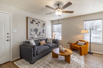 Fort Worth apartment for rent - A living room with a grey couch, a coffee table, and a painting on the wall.