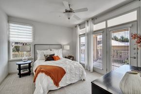 College Station apartment for rent - a bedroom with a large bed and a ceiling fan