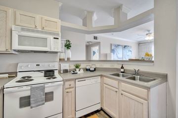 Bryan apartment for rent - a kitchen with white appliances and wooden cabinets