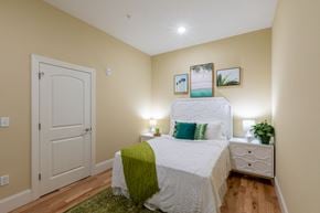 Lawrence apartment for rent - a bedroom with a white bed and a green blanket