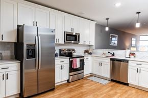 Manchester apartment for rent - a kitchen with white cabinets and stainless steel appliances