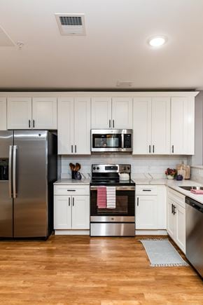 Manchester apartment for rent - a kitchen with white cabinets and stainless steel appliances