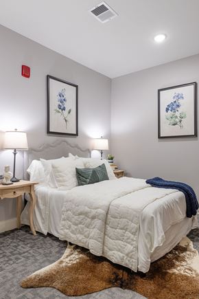 Manchester apartment for rent - A bedroom with a white bed and a brown rug.