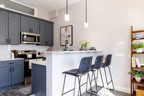 Manchester apartment for rent - A kitchen with a white island and black barstools.