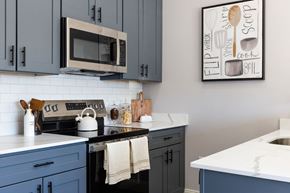 Manchester apartment for rent - A kitchen with a white counter top and a picture of a whiskey glass and a spoon on the wall.
