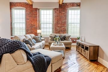 Allenstown apartment for rent - a living room with couches and chairs and exposed brick walls