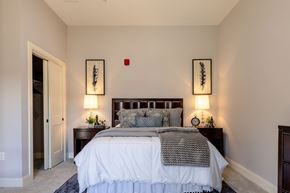 Concord apartment for rent - A bedroom with a large bed and two wall lamps.