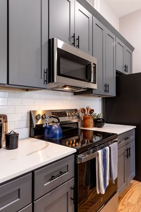Concord apartment for rent - A modern kitchen with dark grey cabinets and a white countertop.