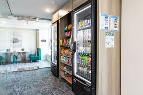 Manchester apartment for rent - A vending machine with a variety of snacks and drinks inside a modern office space.