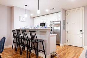 Manchester apartment for rent - A kitchen with a white counter and black chairs.
