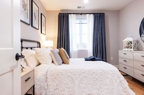 Manchester apartment for rent - A bedroom with a large bed and a window with curtains.