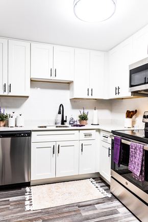 Dover apartment for rent - a kitchen with white cabinets and stainless steel appliances