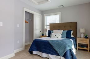 Laconia apartment for rent - A bedroom with a bed, nightstand, and window.