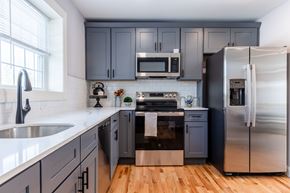 Laconia apartment for rent - A kitchen with a stainless steel refrigerator and a white countertop.