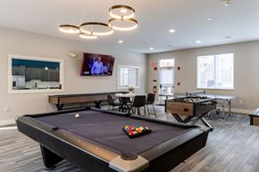 Laconia apartment for rent - A pool table in a room with a television mounted on the wall.