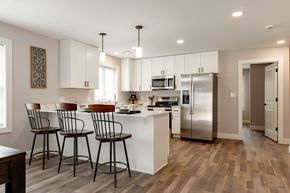 Laconia apartment for rent - A kitchen with white cabinets and a refrigerator.