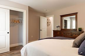 Laconia apartment for rent - A bedroom with a large bed and a wooden dresser.