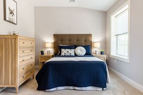 Laconia apartment for rent - A bedroom with a large bed and a wooden dresser.