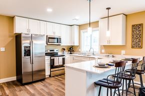 Laconia apartment for rent - a kitchen with white cabinets and a large island with a breakfast bar