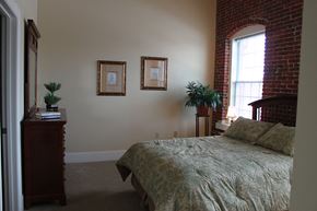 Manchester apartment for rent - a bedroom with a bed and a brick wall