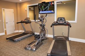 Manchester apartment for rent - two treadmills in a gym with a tv on the wall