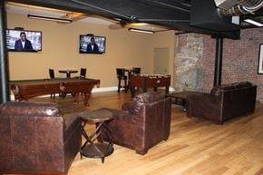Manchester apartment for rent - a game room with couches a pool table and televisions