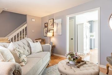 Milford apartment for rent - A living room with a grey couch and a round ottoman.
