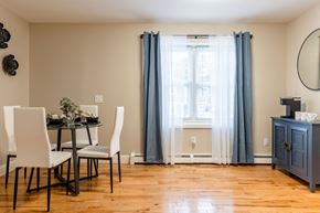 Manchester apartment for rent - A dining room with a table set for two and a window with curtains.