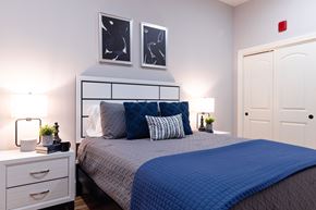 Manchester apartment for rent - A bedroom with a bed, nightstand, and two framed pictures on the wall.