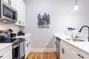Manchester apartment for rent - A kitchen with white cabinets and a black stove top.