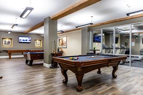 Manchester apartment for rent - A pool table is in the middle of a room with a wooden floor.