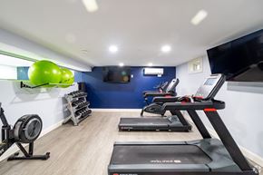 Manchester apartment for rent - A gym with treadmills, elliptical machines, and a fan.