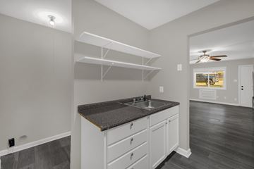 Greensboro apartment for rent - A kitchen with white cabinets and a dark countertop.