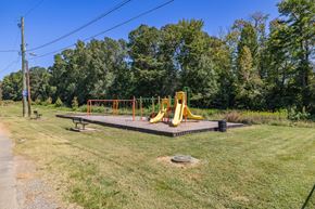 Greensboro apartment for rent - A playground with a yellow slide and a bench.