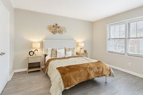 Jacksonville apartment for rent - A bedroom with a large bed and a chandelier.