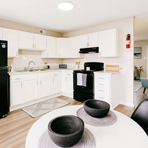 Jacksonville apartment for rent - A black refrigerator sits in a kitchen with white cabinets and a black oven.