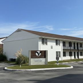 Jacksonville apartment for rent - A white building with a sign that says "Osprey Cove" in front of it.