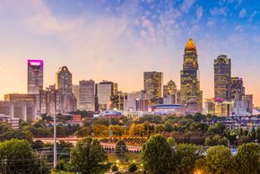 Charlotte apartment for rent - A city skyline at sunset with a prominent building in the center.
